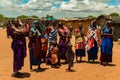 Maasai women in traditional dress communicate with each other and laugh