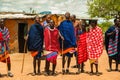 Massai men, wearing traditional blankets, overlooks Serengetti in Tanzania and Kenya in traditional massai village