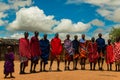 Massai men, wearing traditional blankets, overlooks Serengetti in Tanzania and Kenya in traditional massai village