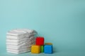 Diapers and plastic cubes on blue background. Space for text