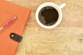 Diary book and pen with black coffee cup on wooden table Royalty Free Stock Photo