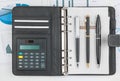 Diary, calculator and three pen lying on a background of diagram Royalty Free Stock Photo