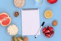 Diary copy space lies on a blue background. Strawberries, lemon, cottage cheese, grapefruit, walnuts lie nearby. Healthy lifestyle