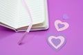 diary next to hearts on purple background Royalty Free Stock Photo