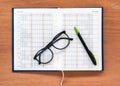 Diary planner book open calendar page with glasses and pen on th Royalty Free Stock Photo