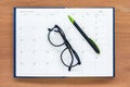 Diary planner book open july calendar page with glasses and pen on th Royalty Free Stock Photo