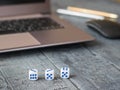 Dice with blue dots, notebook and pens on a wooden table. Royalty Free Stock Photo