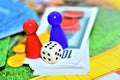 Dice, blue, red figures, chips and game money on the board