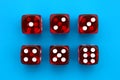 Six red dice lie on an isolated blue background. Royalty Free Stock Photo