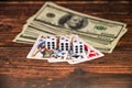 Dice, dollars and playing cards on a dark wooden background, money gambling Royalty Free Stock Photo