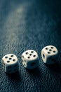 Dice with fives on a dark blue leather table