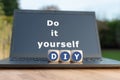 Dice form the abbreviation `DIY`. Dice placed on a Notebook. The text `Do it Yourself` is written on the display.