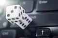 Dice on laptop computer keyboard. ÃÂ¡oncept of online gambling and online casino. Creative idea with devil`s bones and PC keyboard. Royalty Free Stock Photo