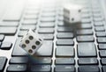 Dice on laptop computer keyboard. ÃÂ¡oncept of online gambling and online casino. Creative idea with devil`s bones and PC keyboard. Royalty Free Stock Photo