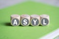 Dice on a notebook forming the word `asylum` Royalty Free Stock Photo