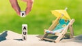 Dice placed next to a beach chair form the German word `faul` `lazy` in English Royalty Free Stock Photo