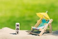 Dice placed next to a beach chair form the word `hot`