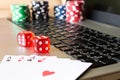 Dice, poker chips and playing cards on laptop. The concept of on