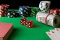 Dice, poker chips, playing cards and twisted 100 banknotes on th