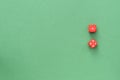 Dice of red color on a green background. Top view, copy space. Gambling concept Royalty Free Stock Photo