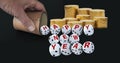 Dice spelling Happy New Year when tumbling out of a raffle cup hold by one hand with stacks of golden coins on black background.