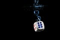 Dice with the number six face in the water with black background Royalty Free Stock Photo