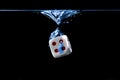 Dice with the number four face in the water with black background
