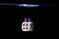 Dice with the number four face in the water with black background