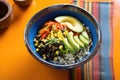 diced avocado, corn, and black beans in a blue bowl