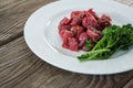 Diced beef and corainder leaves in white plate