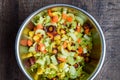 Diced rainbow carrots and chopped celery in a stainless-steel bowl, on a wood table Royalty Free Stock Photo