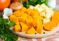 Diced vegetables for cooking pumpkin soup on a wooden background. Healthy food concept. Close-up