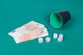 Dices with cup and euros on green cloth Royalty Free Stock Photo