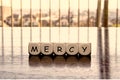5 dices forming the Word `mercy`