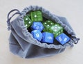 Grey bag, or pouch full of dices. Dices for rpg, board games, tabletop games or dungeons and dragons. Royalty Free Stock Photo