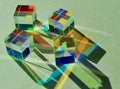 Dichroic square cube prism spreading beam of natural light into colorful shade and shadow.