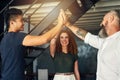 We did it. three creative businesspeople high fiving in their office.