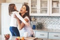 When did you get so big. a happy mother hugging her cute little girl in the kitchen at home. Royalty Free Stock Photo