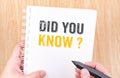 Did you know? word on white ring binder notebook with hand holding pencil on wood table,Business concept