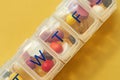 Did you take your pills today. Studio shot of tablets in a medicine organizer against a yellow background. Royalty Free Stock Photo