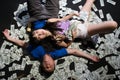 Died young asian couple surrounded by dollar bills. Suicide with a gunshot