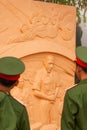 Portrait of young vietnamese soldier in green uniform looking at statue of the French General De Castries at the bunker. Dien Bien