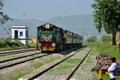 Diesel electric train locomotive speeds past student