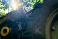 Diesel engine of a walk-behind tractor with a belt drive close-up. Foreshortened view from below with light from the sun