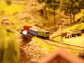 Diesel locomotive pulls wagons along the railroad in a picturesque place. layout of the landscape with the railway, cars,