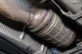 A diesel particulate filter in the exhaust system in a car on a lift in a car workshop, seen from below. Royalty Free Stock Photo