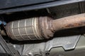 A diesel particulate filter in the exhaust system in a car on a lift in a car workshop, seen from below. Royalty Free Stock Photo