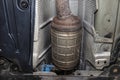 A diesel particulate filter in the exhaust system in a car on a lift in a car workshop, seen from below. Royalty Free Stock Photo