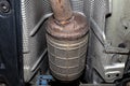 A diesel particulate filter in the exhaust system in a car on a lift in a car workshop, seen from below. Royalty Free Stock Photo