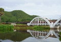 Diesel Train passing the Tha Chom Phu railway bridge or white bridge